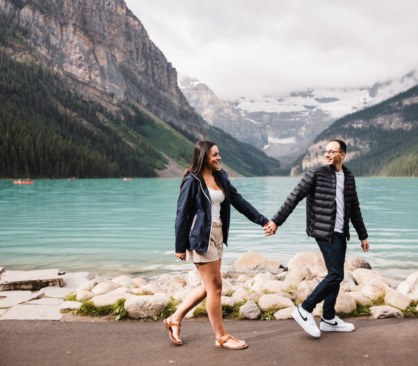 Louise and James holding hands beside Lake Louise